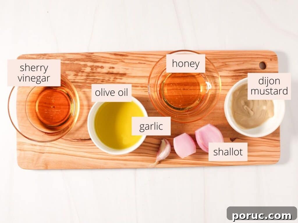 Sherry Shallot Vinaigrette Recipe for Fresh Salads 3 Sherry dressing, olive oil, garlic, shallot, honey and dijon mustard laid out on a wooden board for sherry shallot dressing.