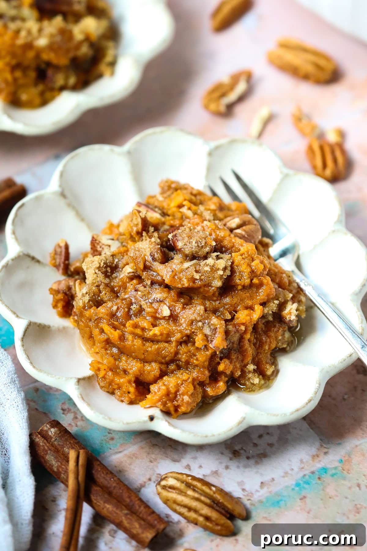 Southern Sweet Potato Casserole with Pecan Crumble Recipe 2 A serving of sweet potato casserole with pecans crumble on a dessert plate.