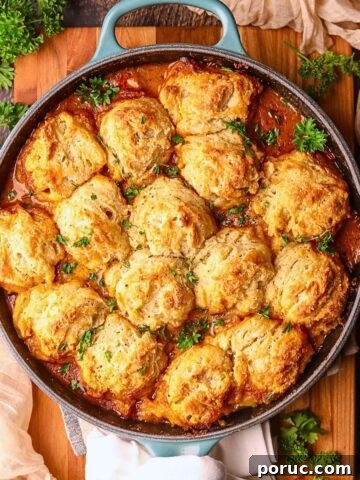 Catfish etouffee pot pie in a cast iron skillet, sitting on a wooden cutting board.