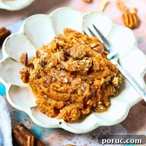 Southern Sweet Potato Casserole with Pecan Crumble Recipe 13 A serving of sweet potato casserole with pecans crumble on a dessert plate.