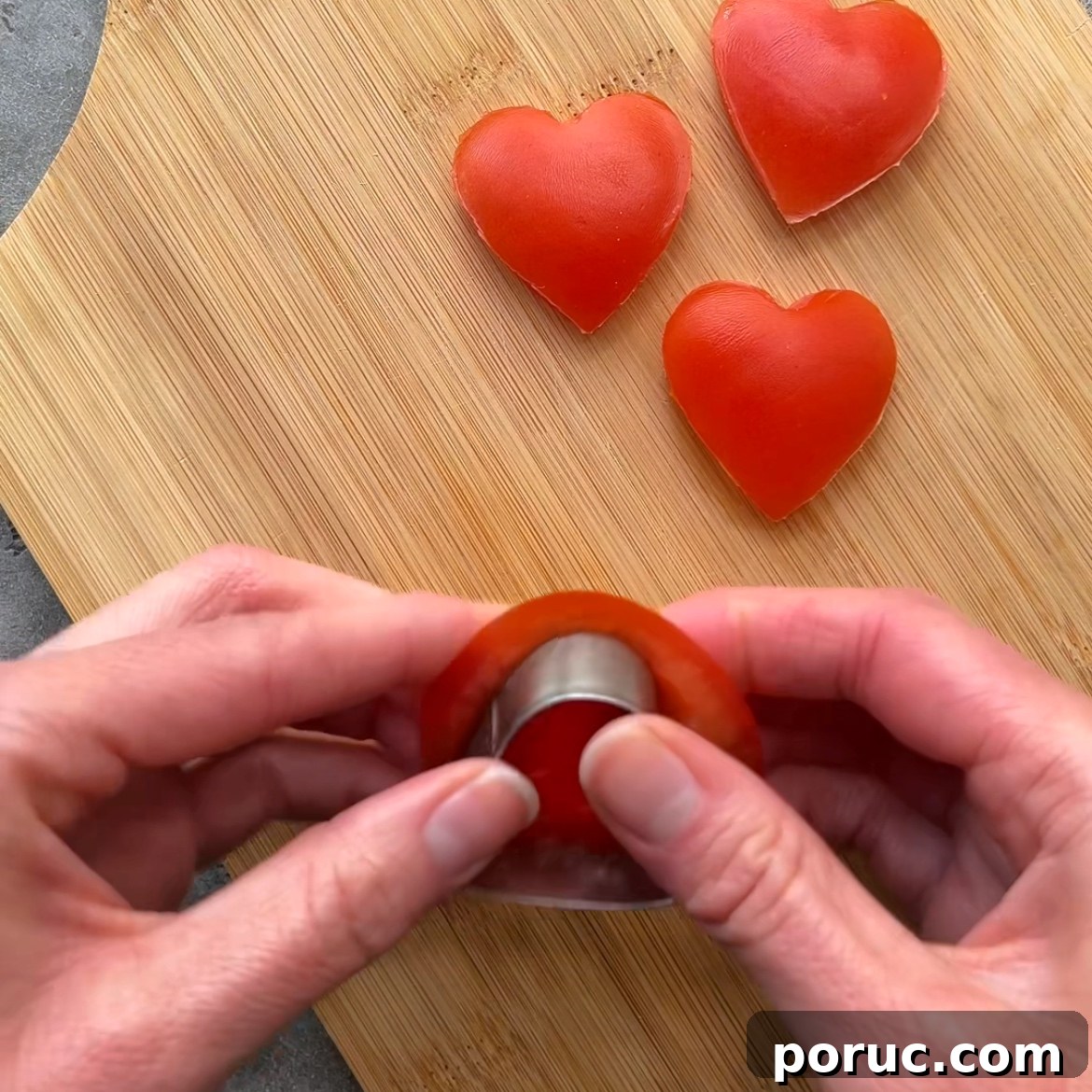 Creamy Avocado & Melted Cheese Toast Recipe 5 Hands using a heart-shaped cutter to make heart-shaped pieces of tomato.