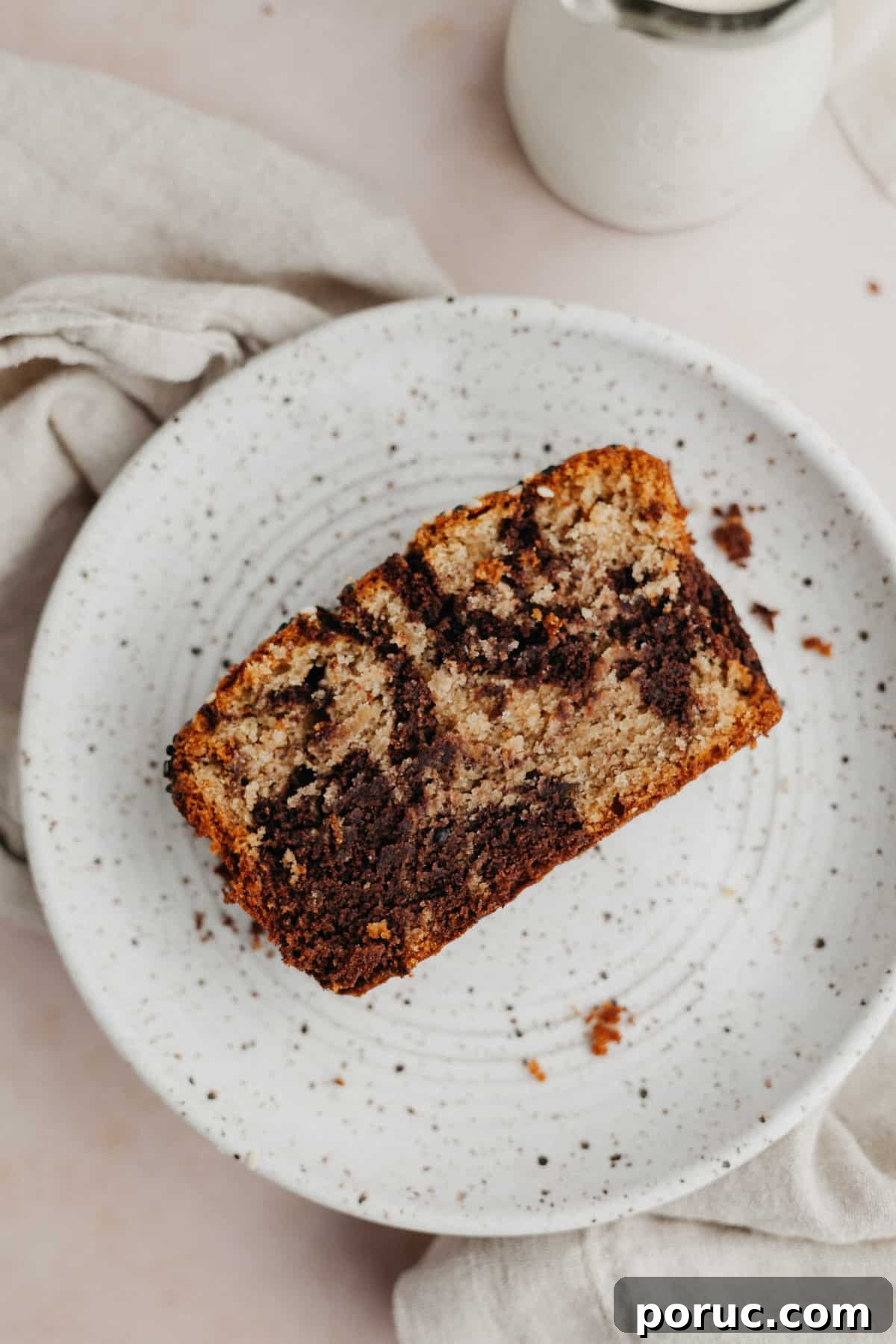 Chocolate Tahini Swirl Banana Bread with Sour Cream Swirl 7 a slice of swirled chocolate tahini banana bread on a small plate.