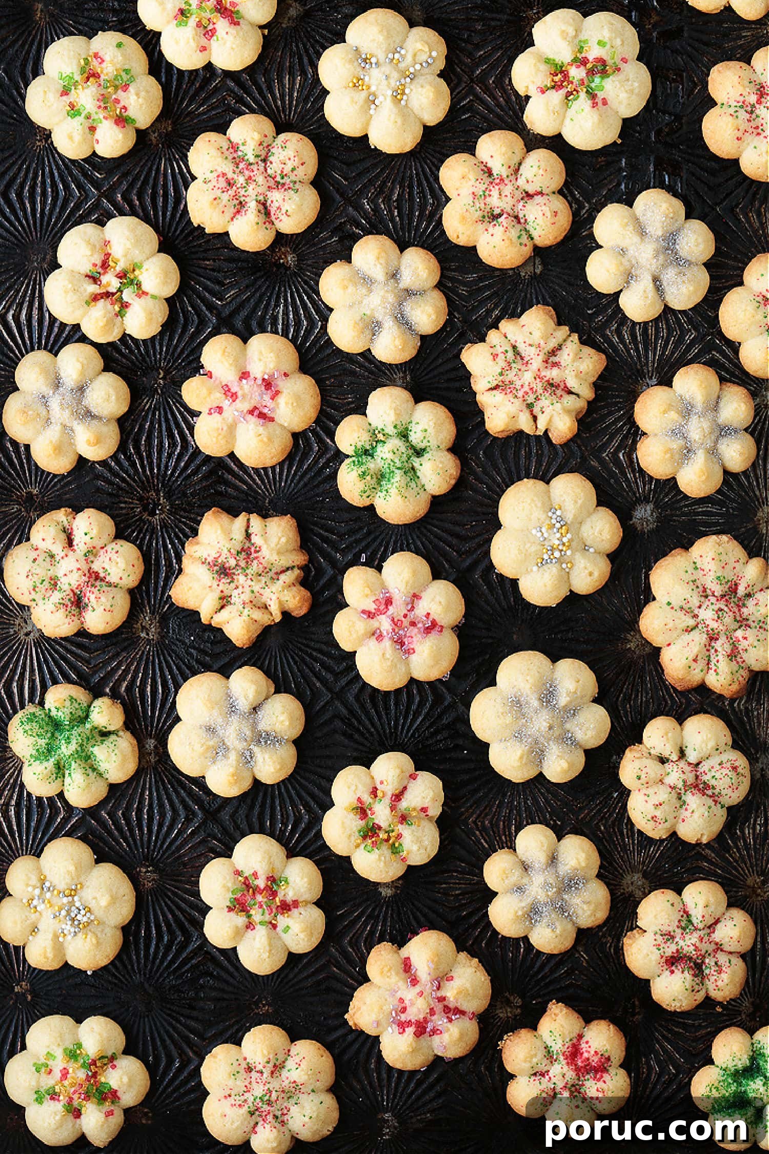 Grandma's Spritz Cookies are a family favorite! Buttery, festive cookies with a hint of sweetness, topped with colorful sprinkles. spritz cookies on a baking sheet