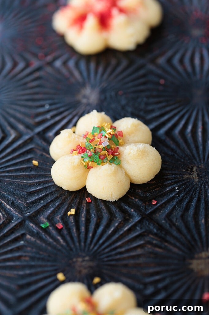 Grandma's Spritz Cookies are a family favorite! Buttery, festive cookies with a hint of sweetness, topped with colorful sprinkles. sprinkles and cookies