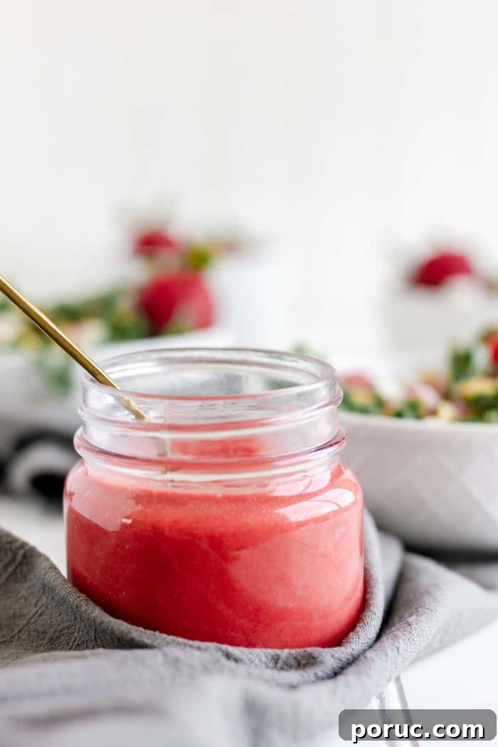 Strawberry Vinaigrette Recipe for Paleo Salads 2 Image shows a jar of raspberry vinaigrette dressing next to a grey napkin