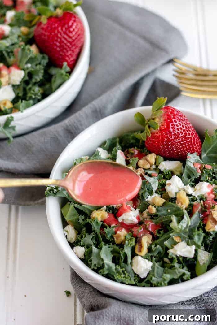 Strawberry Vinaigrette Recipe for Paleo Salads 3 Photo shows two kale salads with strawberries, and a spoon of homemade dressing