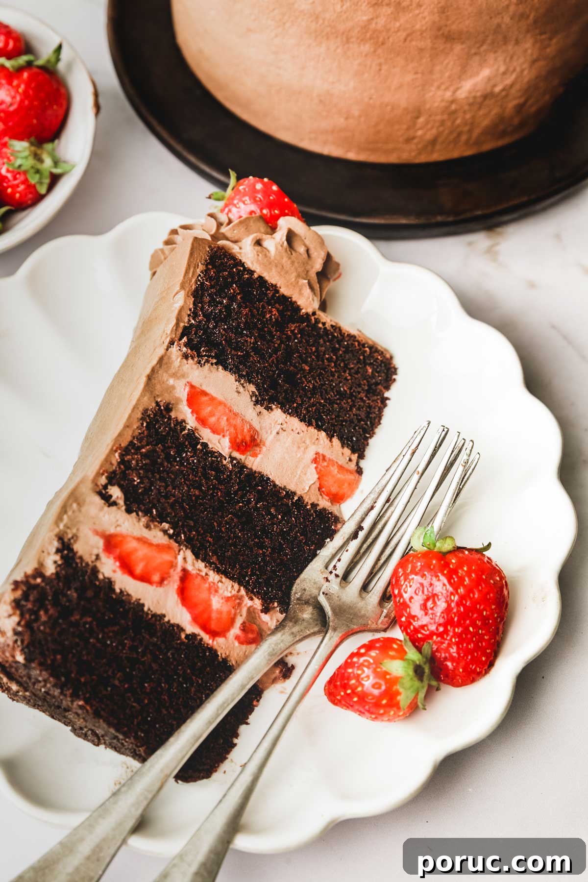Part de gâteau au chocolat dans une assiettes avec des fourchettes et des fraises