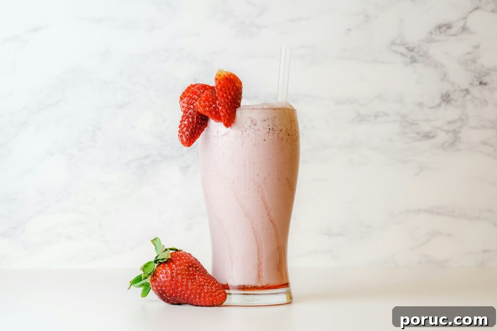 Strawberry oat milk in a glass garnished with strawberries