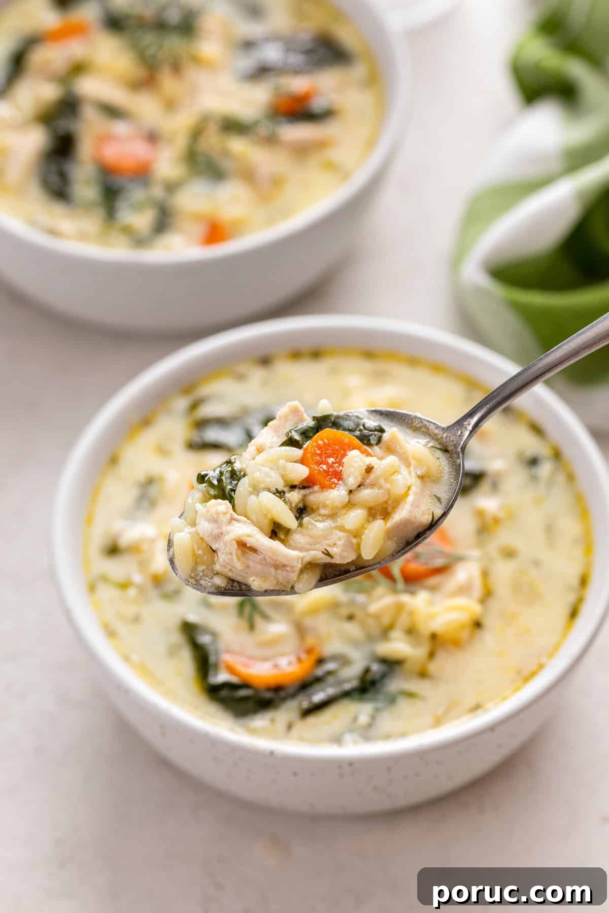 Lemony Chicken and Orzo Soup Recipe for Cozy Meals 11 Spoon holding up a bite of lemon chicken orzo soup.