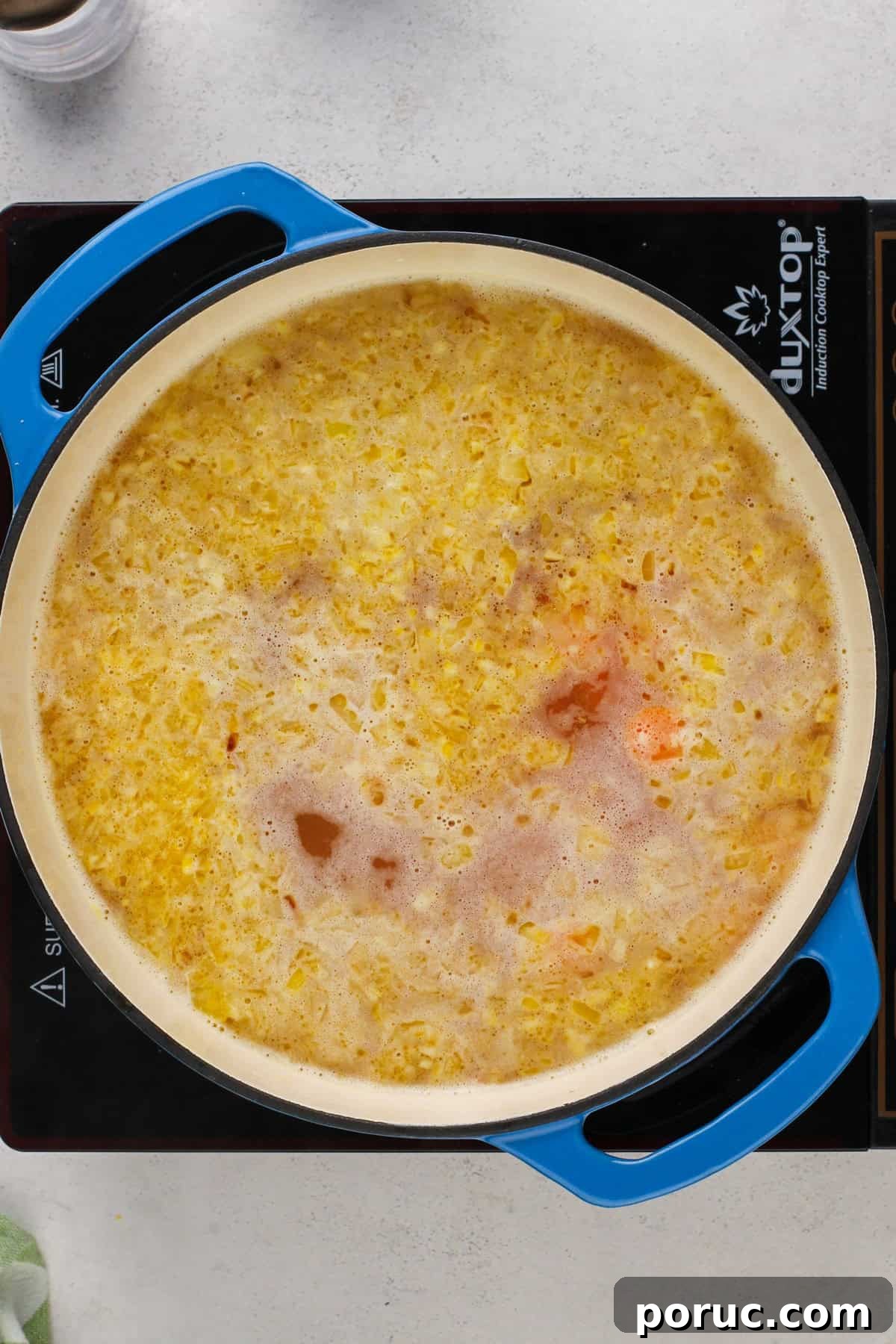 Lemony Chicken and Orzo Soup Recipe for Cozy Meals 7 Orzo and carrots simmering in chicken stock in a dutch oven.