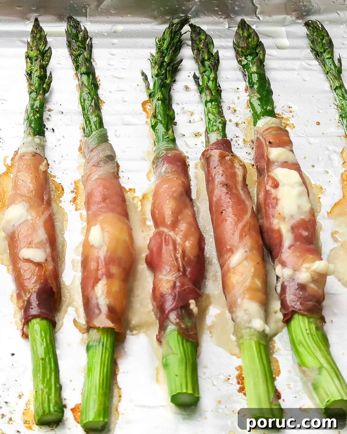 baked Prosciutto Wrapped Asparagus with Cream Cheese spilling out a bit