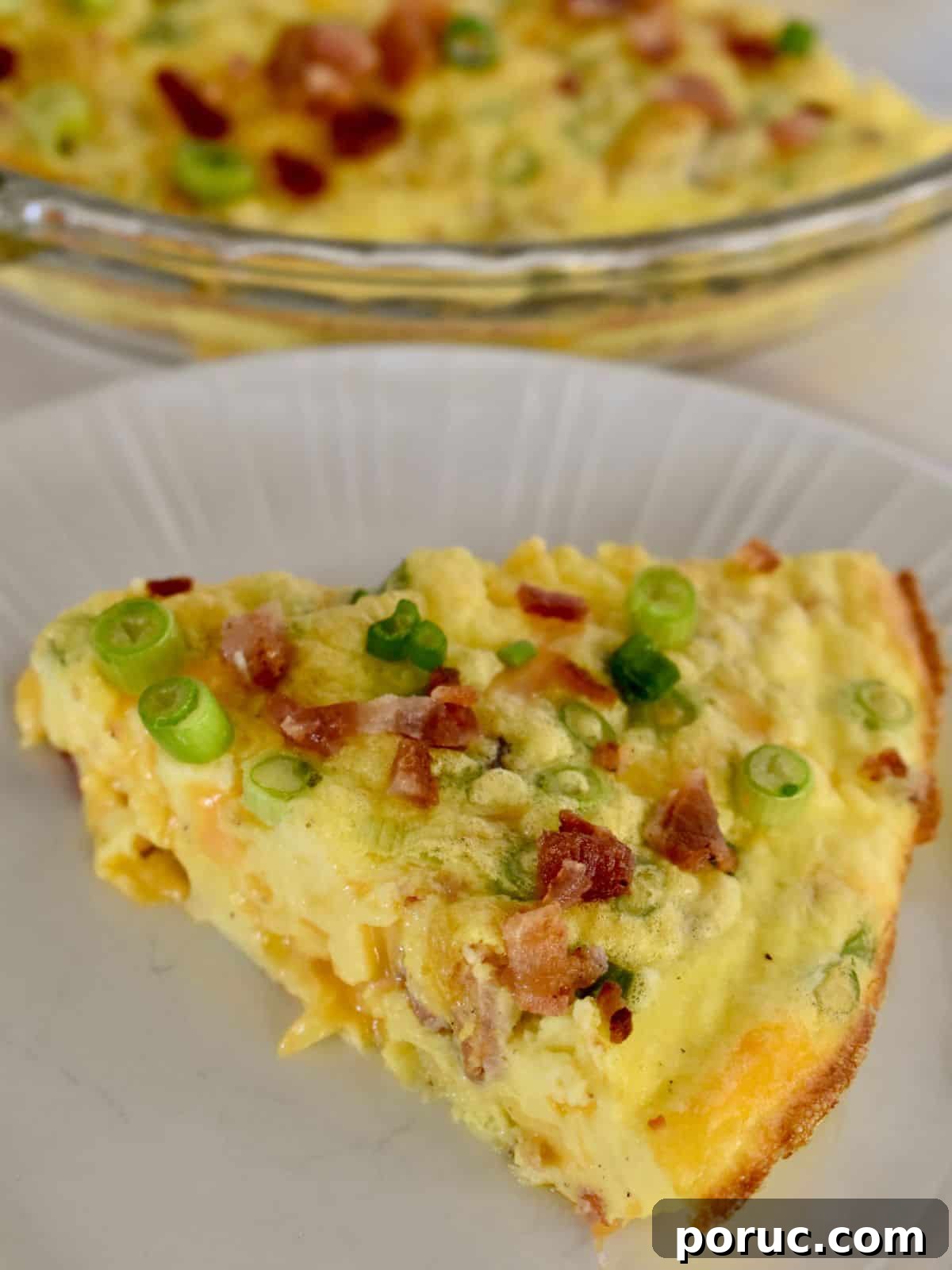 Crustless Cottage Cheese Quiche Recipe: Light Protein-Packed Bake 3 Slice of cottage cheese quiche on a white plate with bacon, cheese, and green onions.