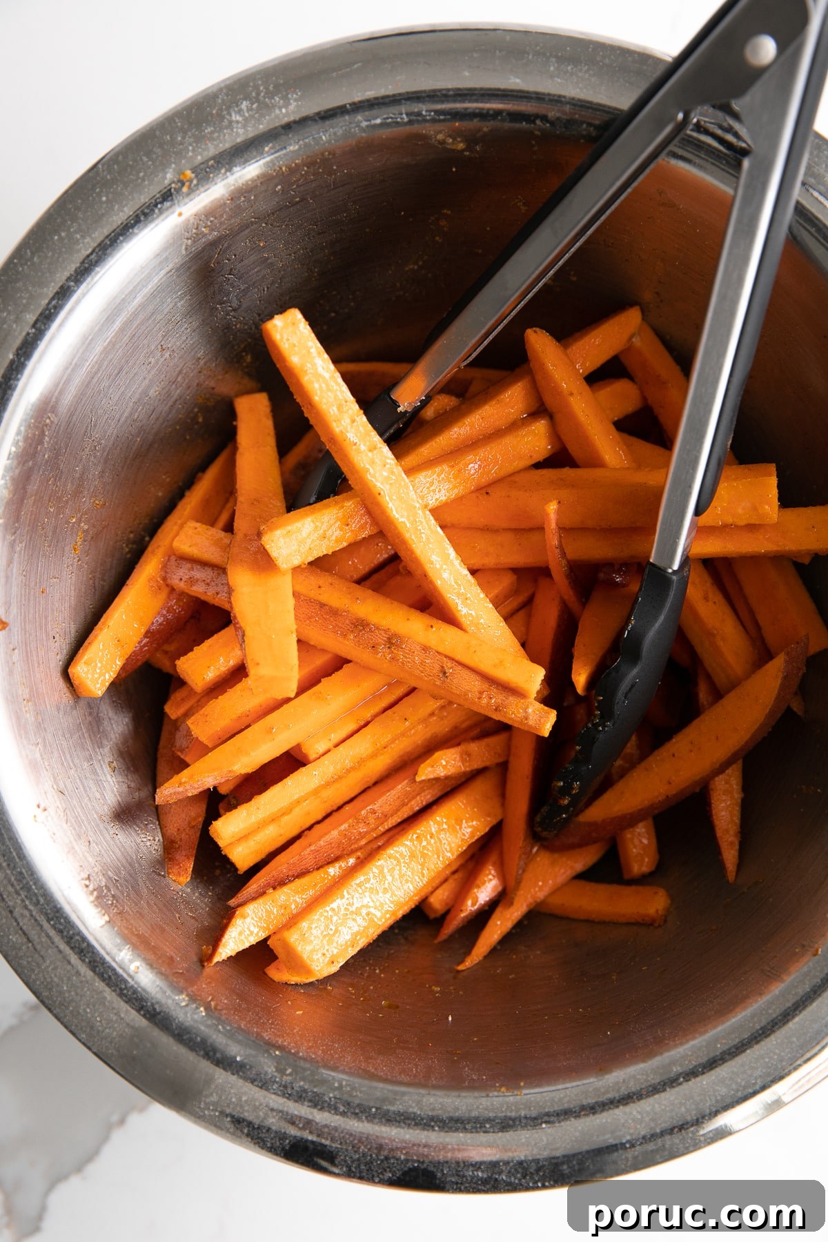 Sweet potato cut into thin matchsticks for french fries and placed in a large bowl tossed with olive oil and seasoning.