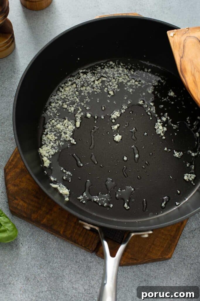 A skillet with oil and minced garlic