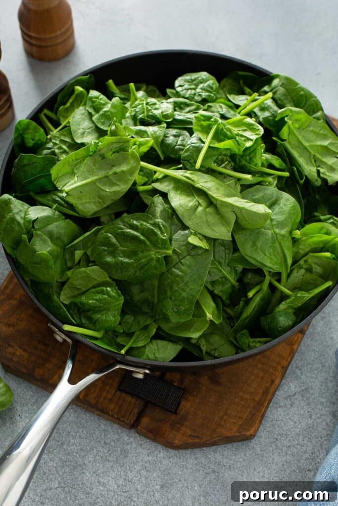 A skillet packed with baby spinach