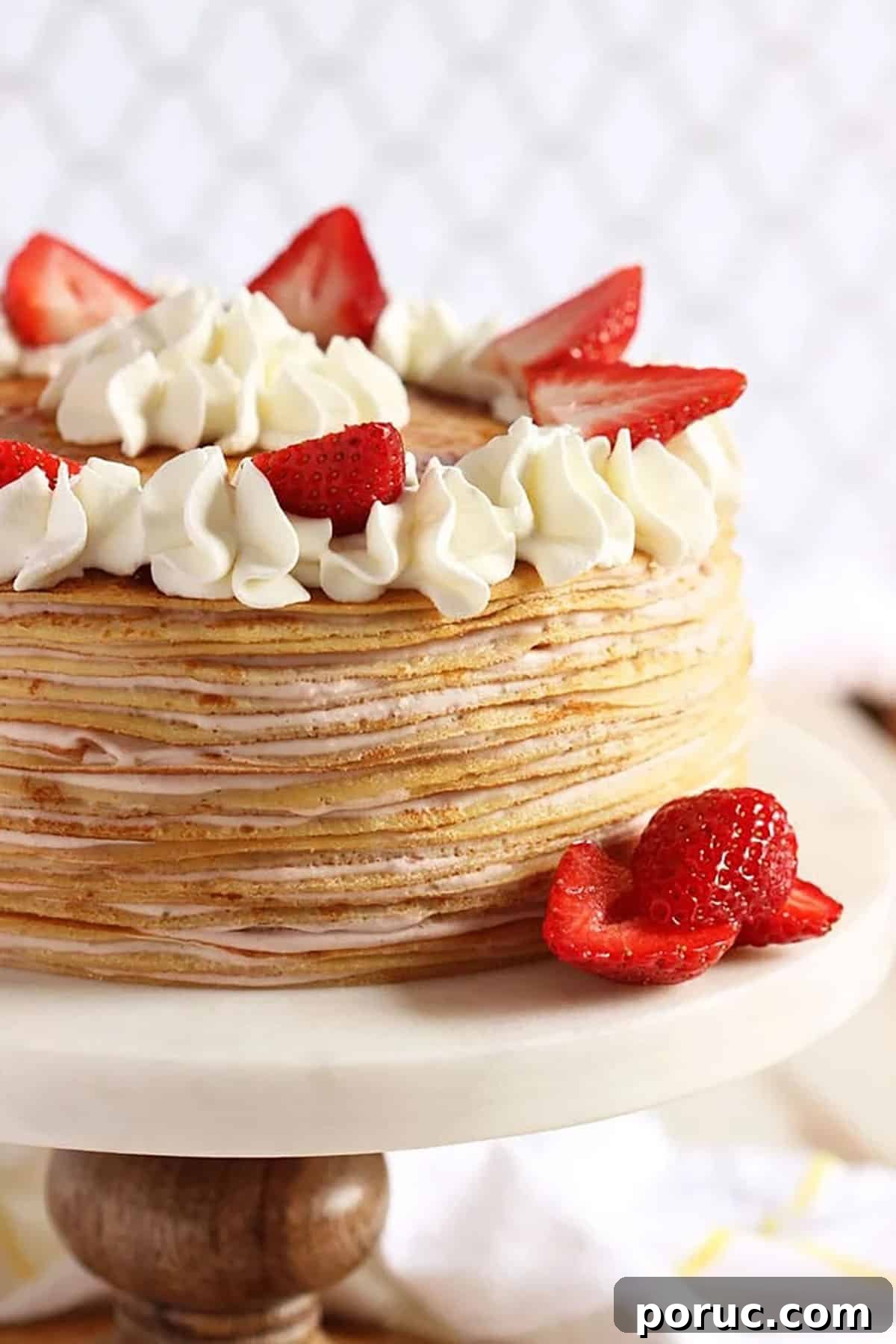 Homemade Crepes: Sweet and Savory Recipes for Any Meal 5 strawberry crepe cake on a pedestal with berries and cream