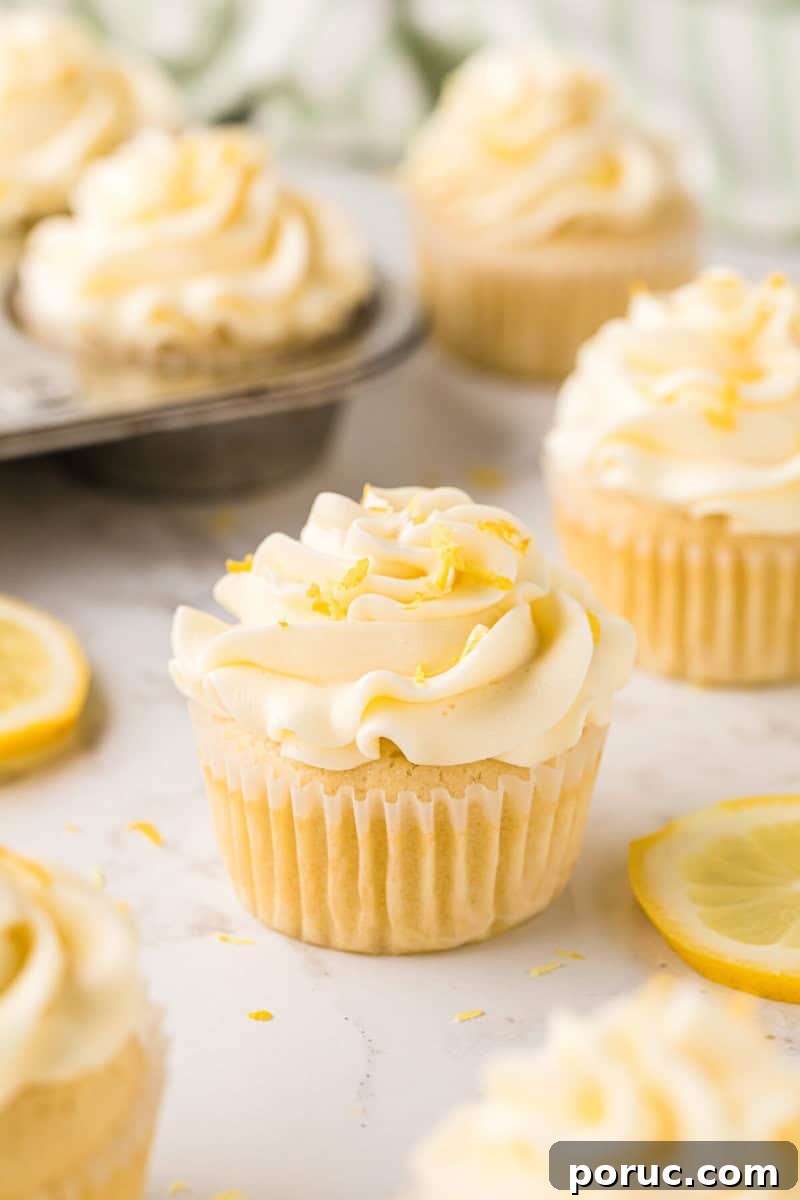Zesty Lemon Cupcakes Recipe with Simple Glaze 10 closeup of a Lemon Cupcake frosted and topped with some lemon zest.