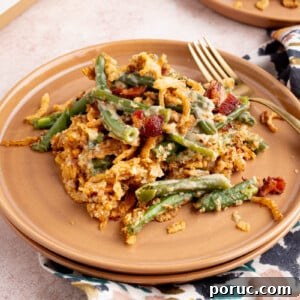 Classic Fresh Green Bean Casserole with Crispy Onion Topping 7 A scoop of green bean casserole on a plate for serving.