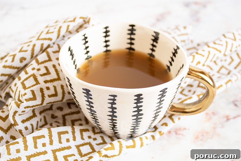 Keto Coconut Lime Shredded Chicken — Instant Pot or Slow Cooker 3 keto bone broth in a striped cup with a gold handle on a gold napkin