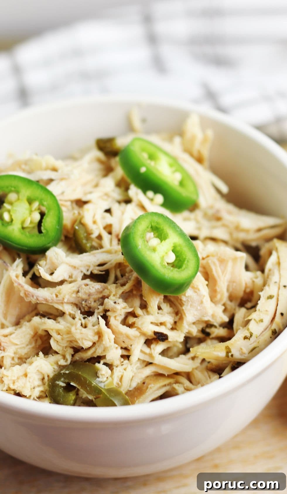 Keto Coconut Lime Shredded Chicken — Instant Pot or Slow Cooker 5 overhead view of keto coconut curry chicken in a white bowl by a white towel