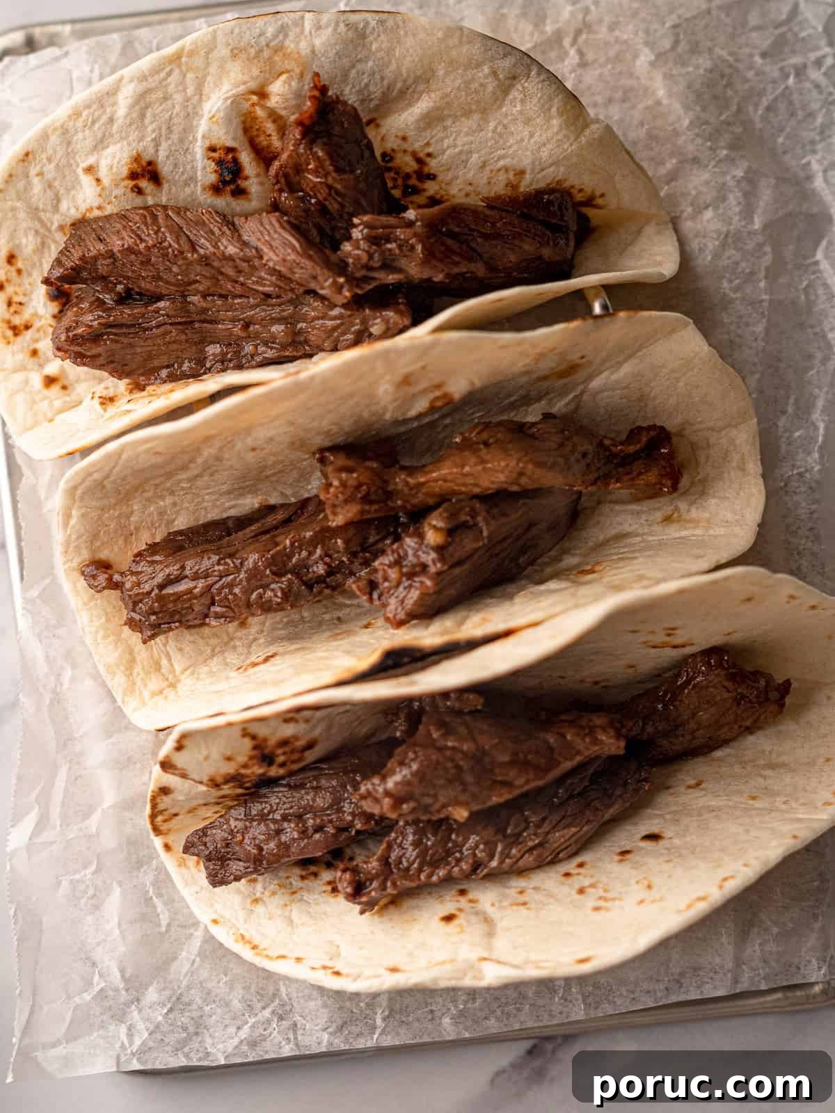Korean BBQ Beef Tacos with Spicy Gochujang Slaw 7 Steak slices in three tortillas.
