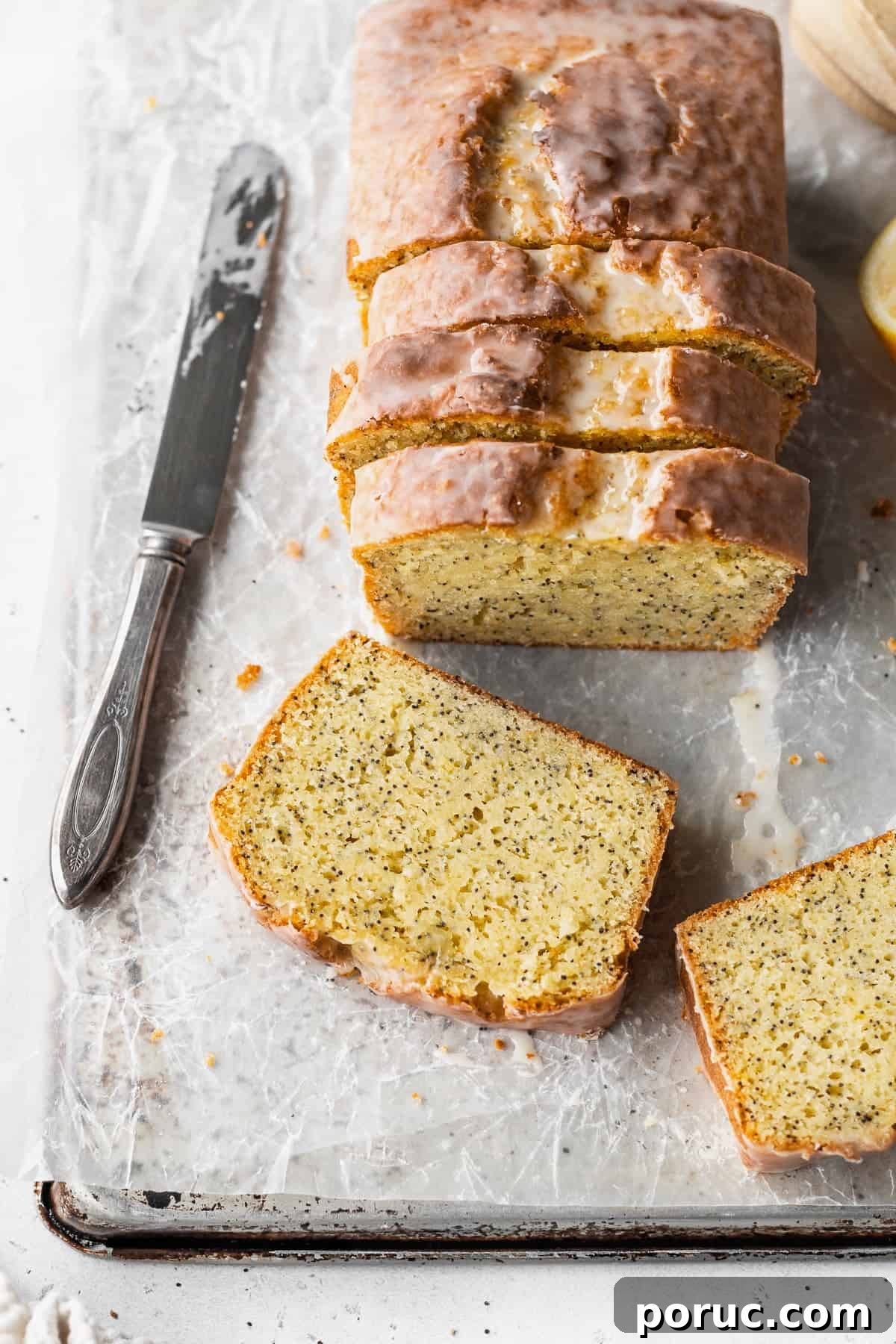 Gluten-Free Lemon Poppy Seed Cake Recipe 5 Overhead shot of a sliced lemon poppysead loaf with two slices laying in front of it.