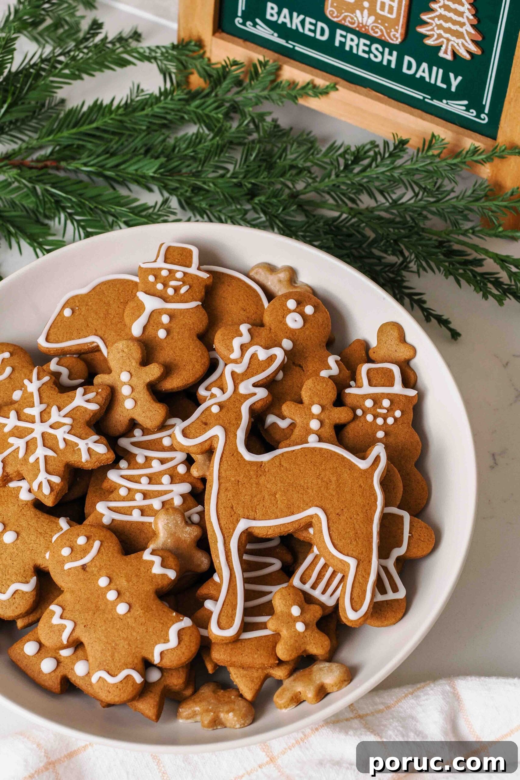 Classic Gingerbread Cookies Recipe for Crisp, Spiced Treats 2 A platter of gingerbread cookies by a pine bough.