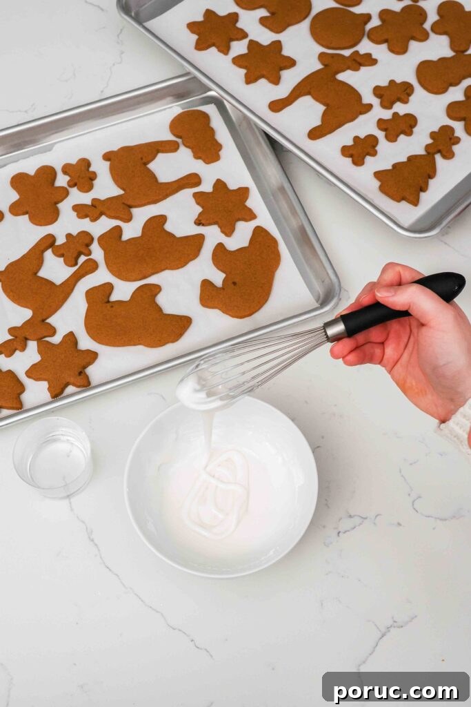 Classic Gingerbread Cookies Recipe for Crisp, Spiced Treats 13 A whisk trails powdered sugar icing into a bowl.