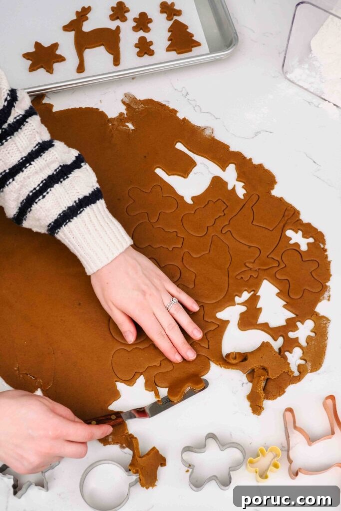 Classic Gingerbread Cookies Recipe for Crisp, Spiced Treats 9 Carefully picking up a dough cutout of a gingerbread man.