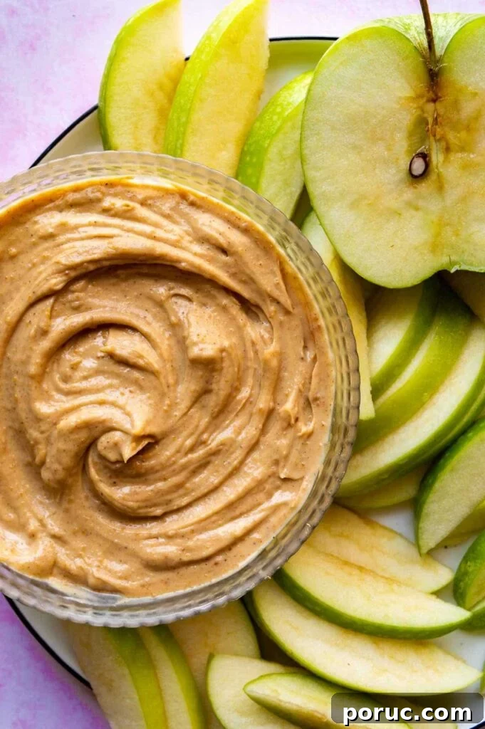 Greek Yogurt Apple Dip Recipe for Sweet & Tangy Snacks 2 A glass bowl with a creamy brown dip surrounded by sliced apple.