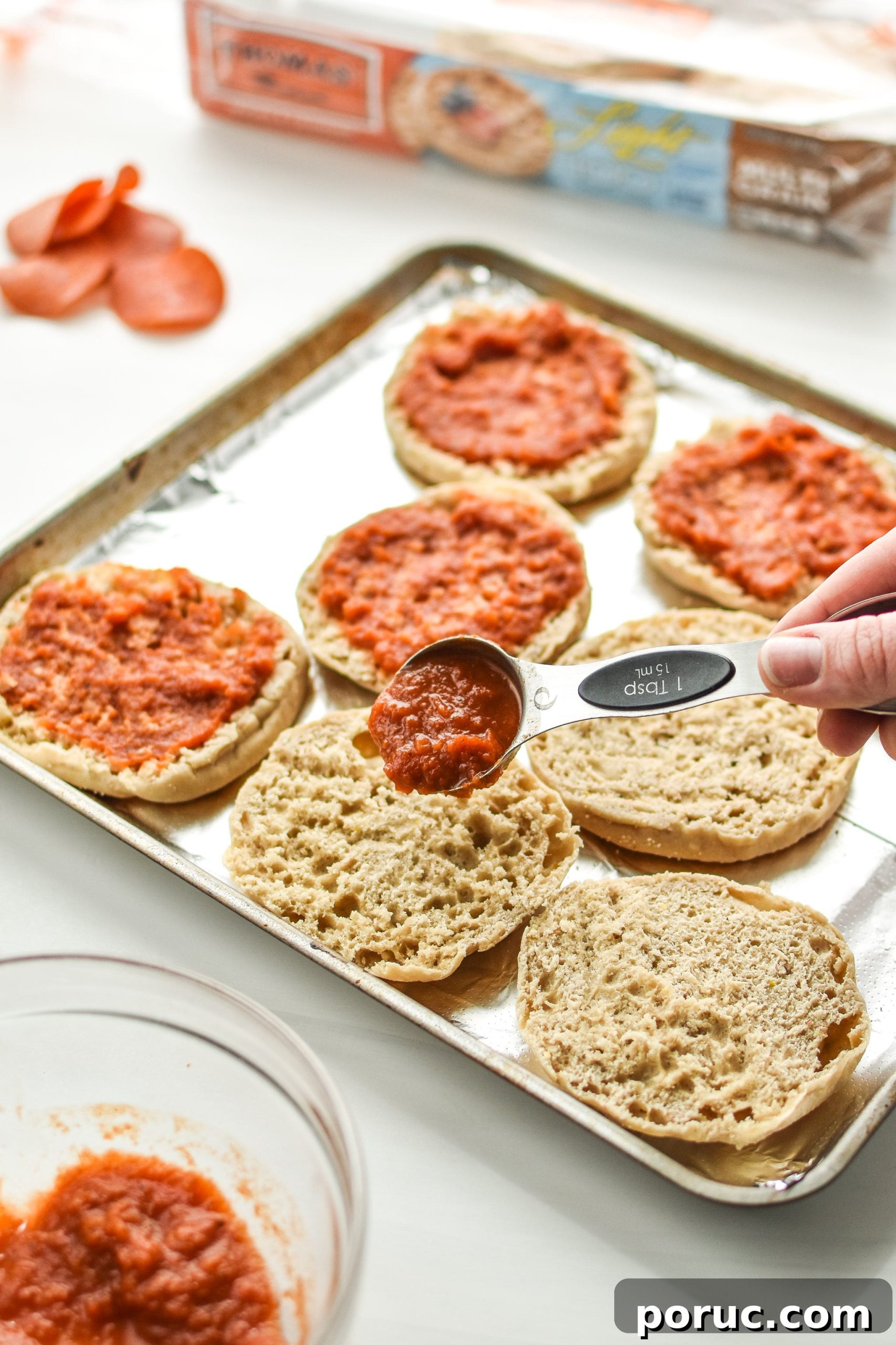 Mini English Muffin Pizzas for Weekly Meal Prep 4 Adding sauce to the english muffins for the english muffin mini pizza meal prep