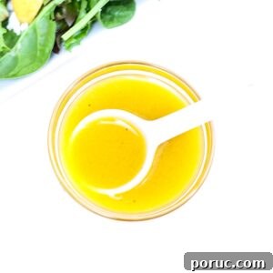 Tangy Apple Cider Vinaigrette Recipe for Salads and Marinades 6 Apple Cider Vinaigrette Dressing in a small glass bowl with a white serving spoon.