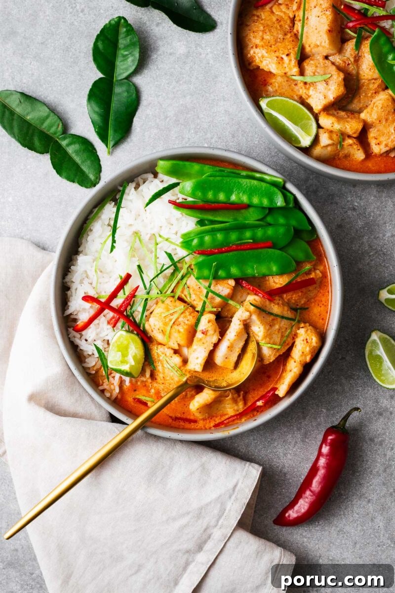 Kake Udon: Classic Japanese Broth Noodle Soup Recipe 14 A bowl with steamed jasmine rice, Thai fish red curry and snow peas topped with sliced red chile and kaffir lime leaves with a golden serving spoon.