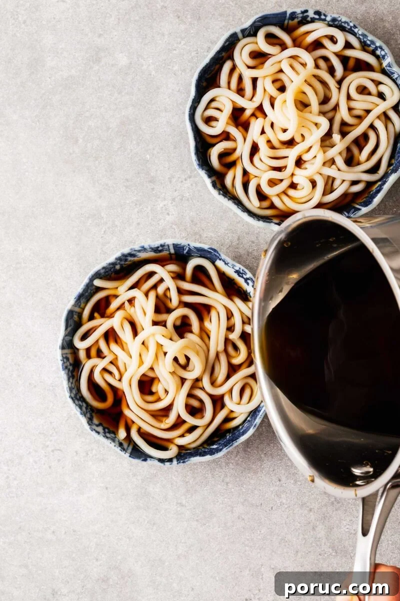 Kake Udon: Classic Japanese Broth Noodle Soup Recipe 10 Pouring dashi broth over cooked udon noodles.