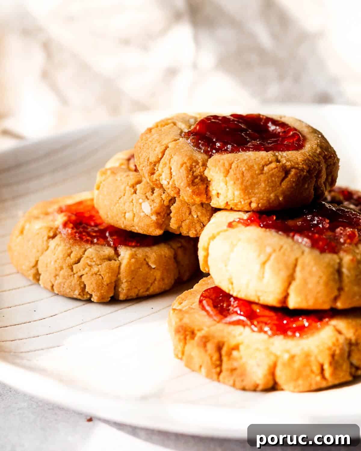 Peanut Butter and Jelly Cookies Recipe — Classic Sandwich Twist 2 Five PB & J cookies stacked in a pyramid on a white plate.