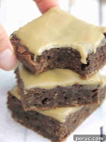Three coffee brownies stacked with a bite taken out of the top one.