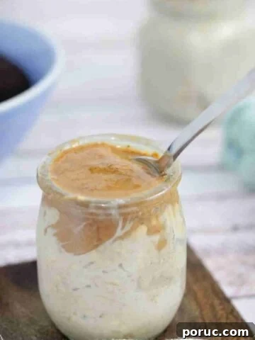 Mason jar with espresso overnight oats topped with almond butter.