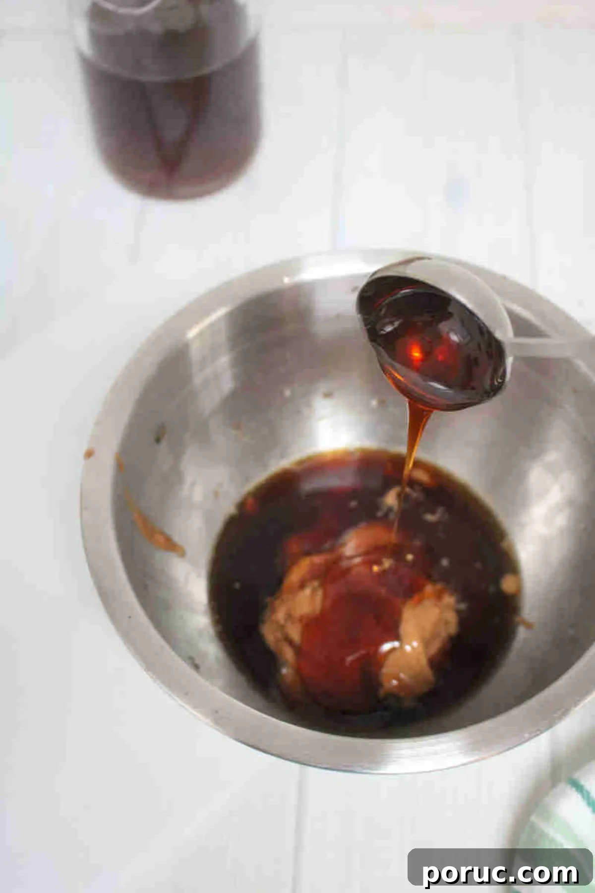 Gluten-Free Coffee Protein Bites: Energy Snacks for Busy Mornings 4 Steel bowl with maple syrup being poured into nut butter and vailla.