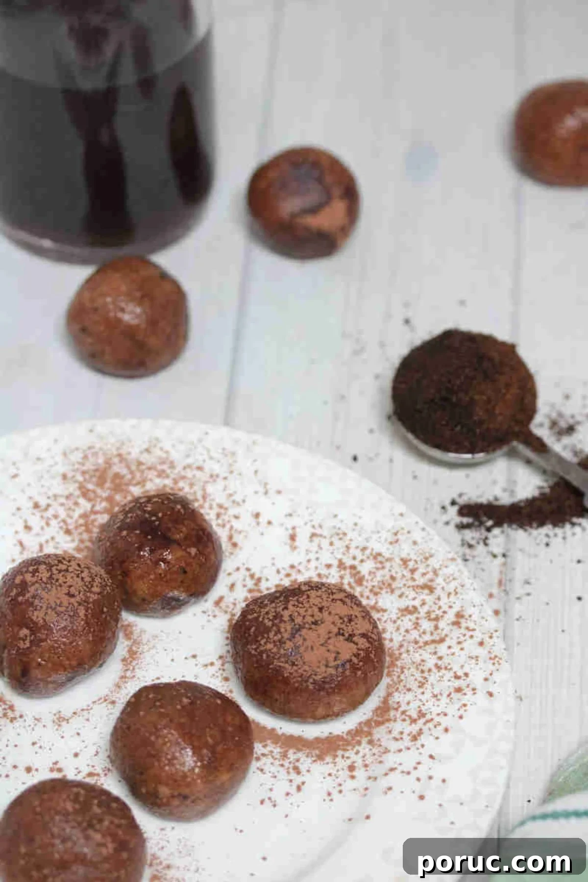 Gluten-Free Coffee Protein Bites: Energy Snacks for Busy Mornings 7 Coffee protein balls dusted in cocoa powder on a white plate.