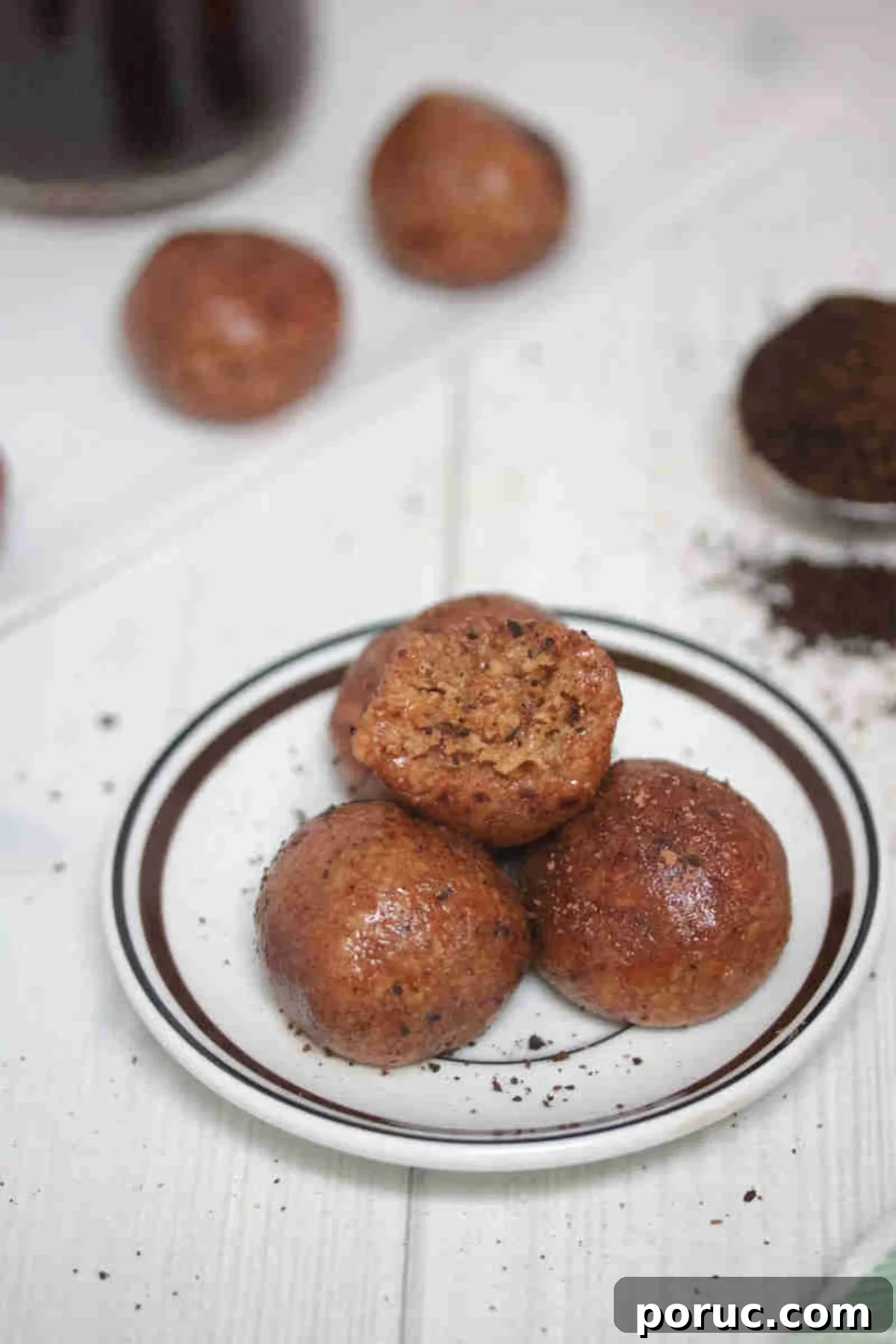 Gluten-Free Coffee Protein Bites: Energy Snacks for Busy Mornings 8 Three coffee protein balls on a white plate the top with a bite out of it.