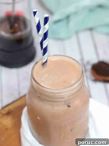 Iced coffee protein shake in a mason jar with blue straws.