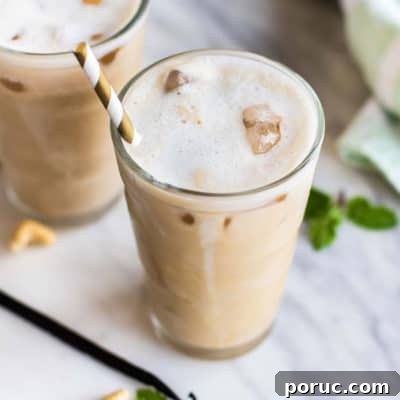 Two frosty glassed of iced vanilla coffee with a foamy top.