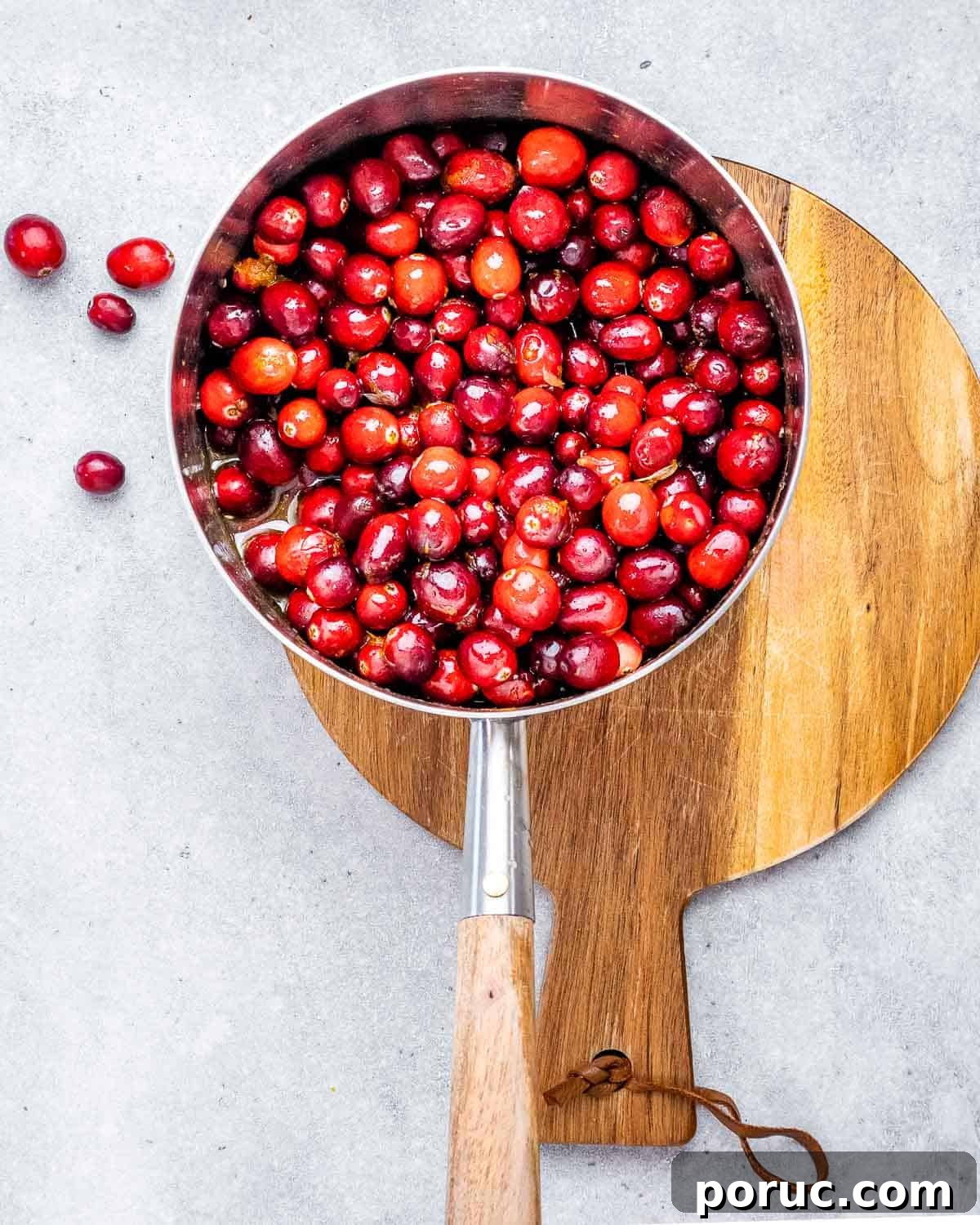 Tangy Cranberry Orange Sauce Recipe for Holidays and Leftovers 4 Cranberries in a saucepan with orange juice and maple syrup.