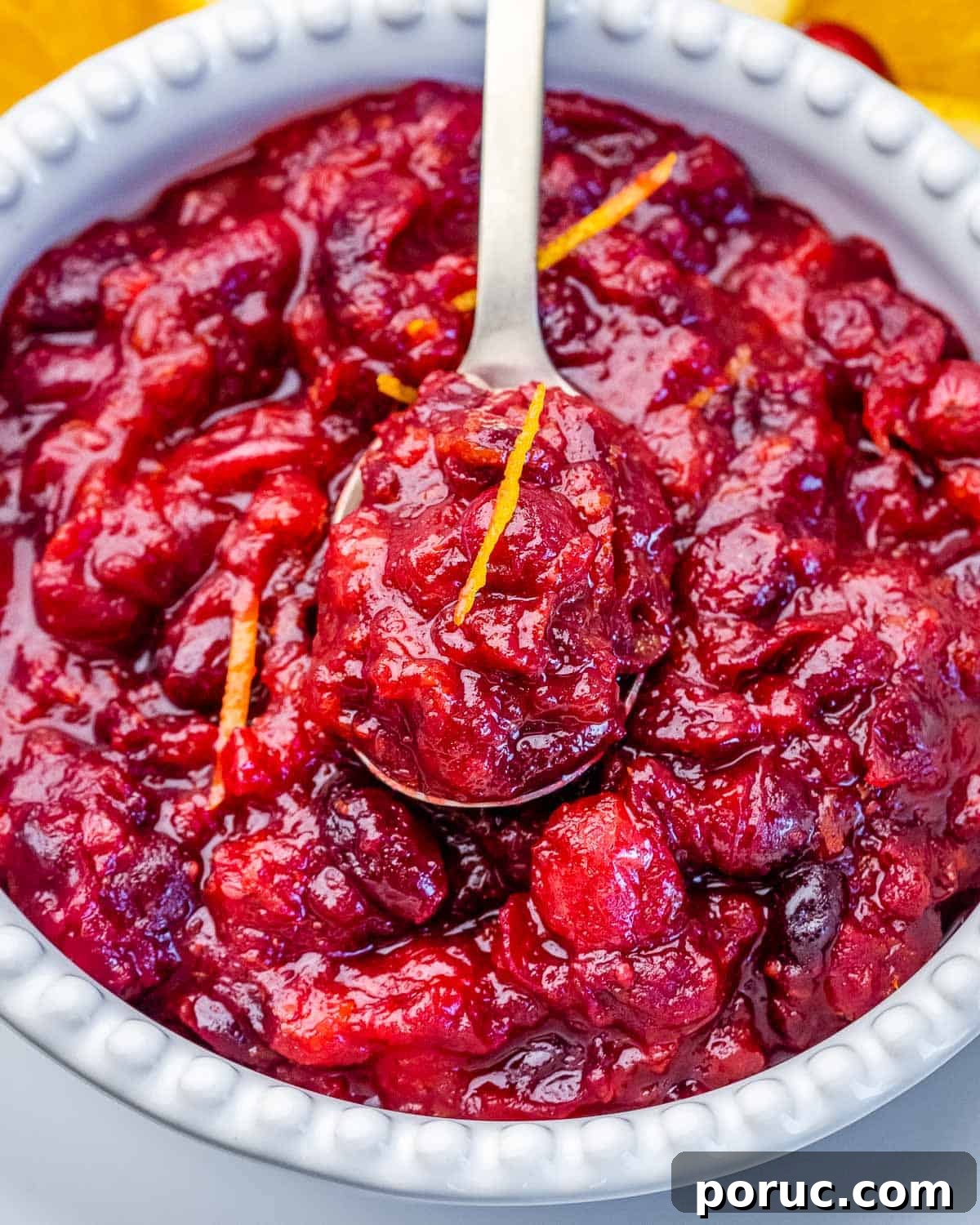 Tangy Cranberry Orange Sauce Recipe for Holidays and Leftovers 6 A spoon in a bowl of cranberry orange sauce.