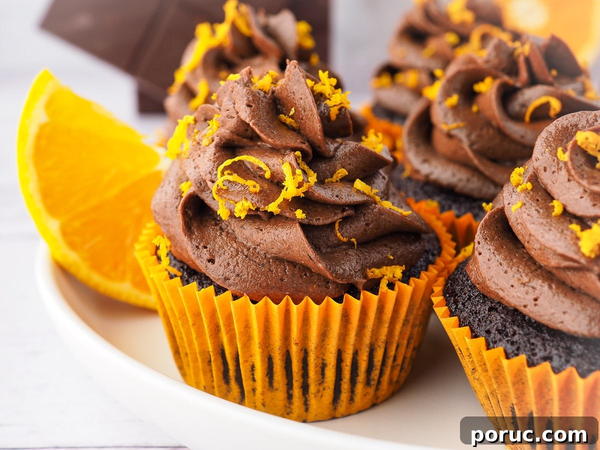Chocolate Orange Cupcakes with Zesty Orange Glaze 9 Cupcakes on a plate with fresh oranges in the background.