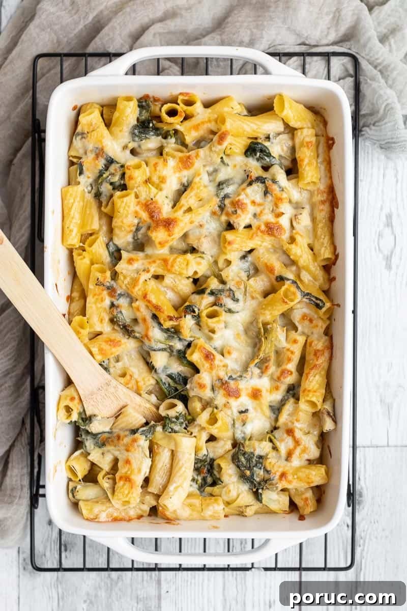 Spinach and Artichoke Pasta Bake with 7 Simple Ingredients 2 baked spinach artichoke pasta in a rectangle baking dish.