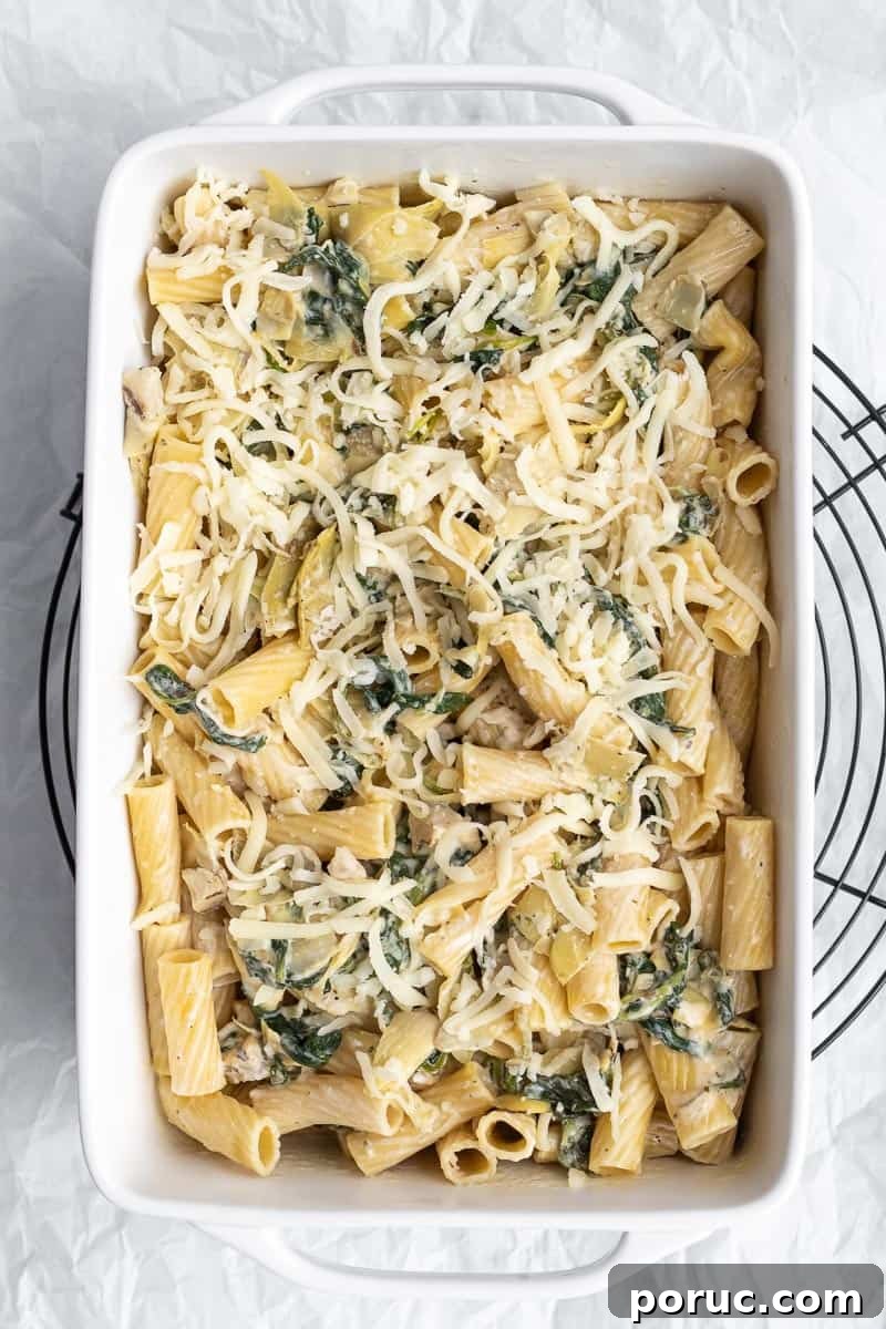 Spinach and Artichoke Pasta Bake with 7 Simple Ingredients 11 pasta in a ceramic pan with mozzarella on top ready to bake