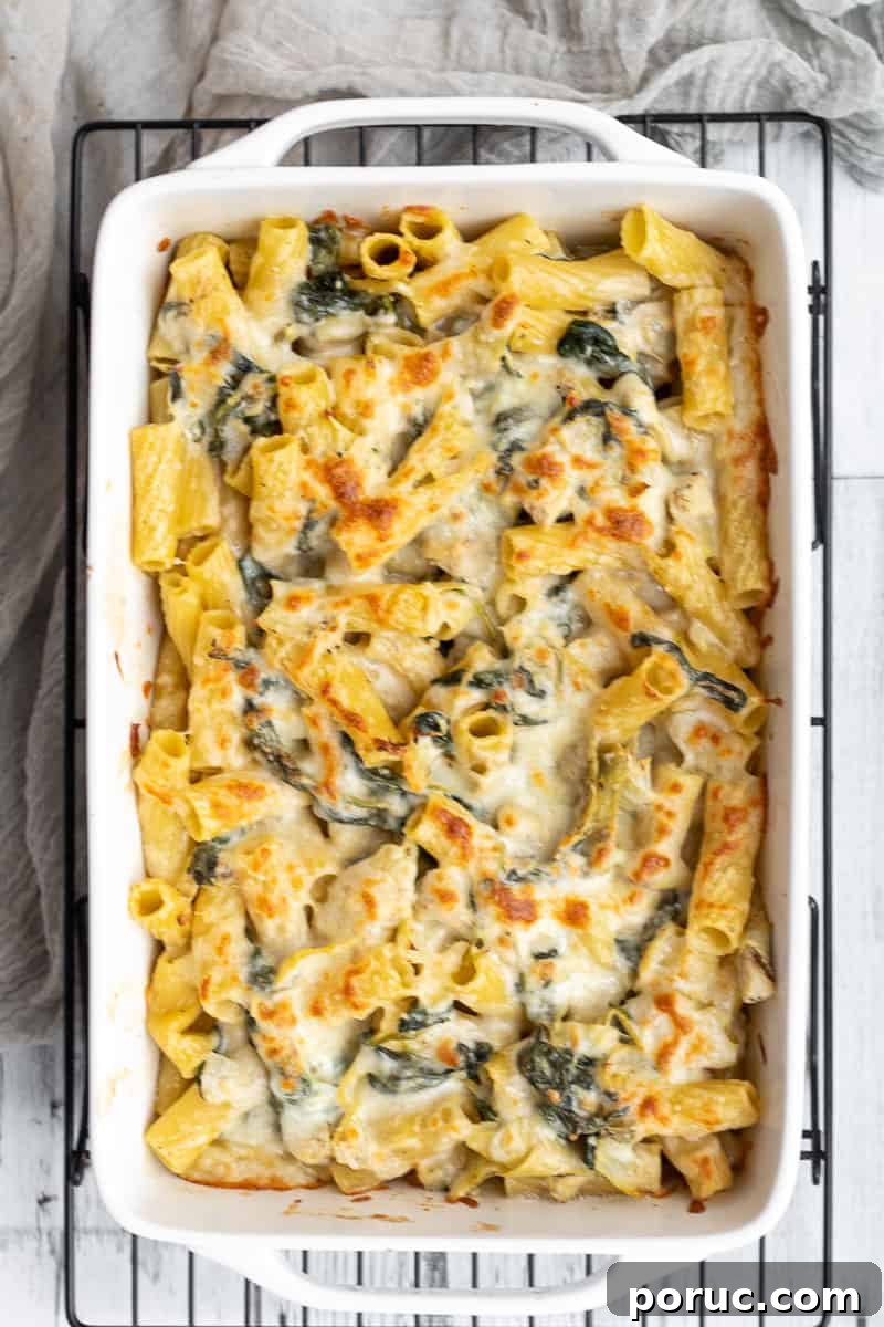 Spinach and Artichoke Pasta Bake with 7 Simple Ingredients 12 Spinach artichoke baked pasta in a white ceramic baking dish.