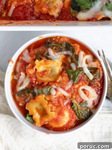 spinach ravioli pasta bake in a white bowl with a fork