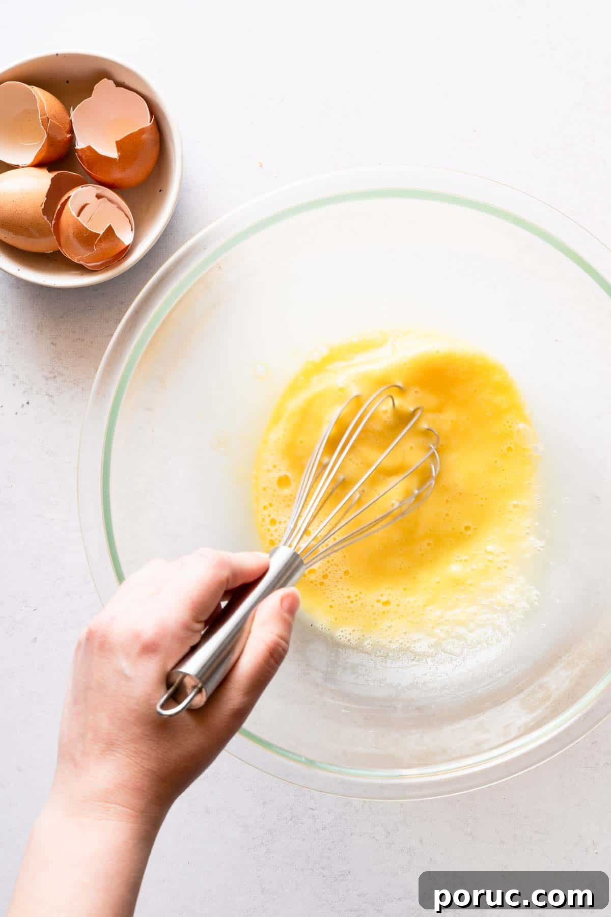eggs being whisked in glass bowl.